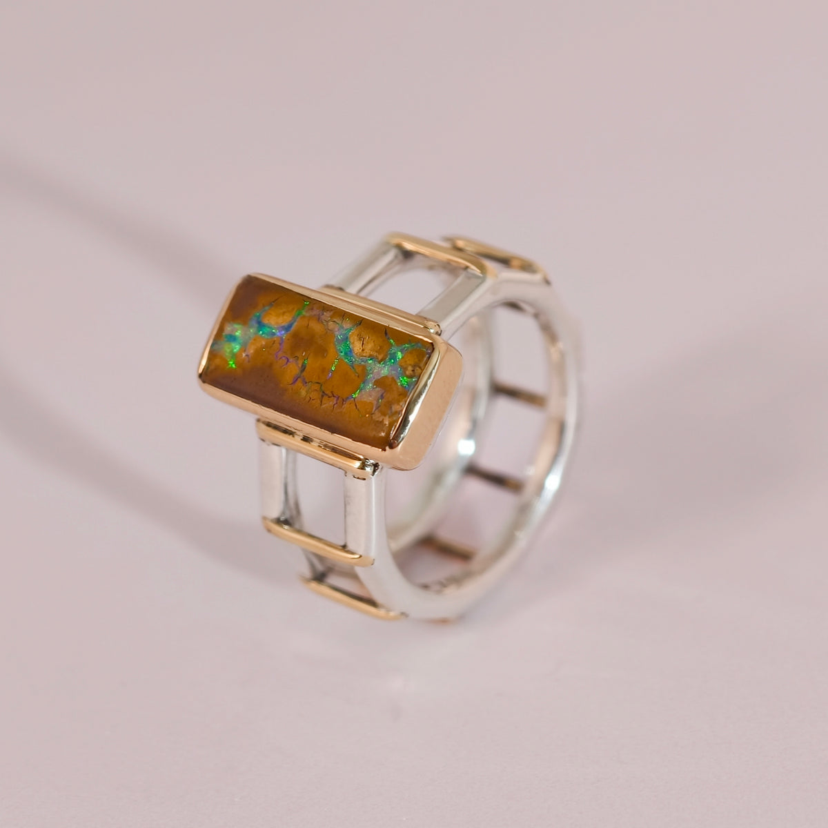Bague Tirou Bijou avec une opale boulder rectangulaire aux reflets verts, sertie sur une monture ajourée bicolore