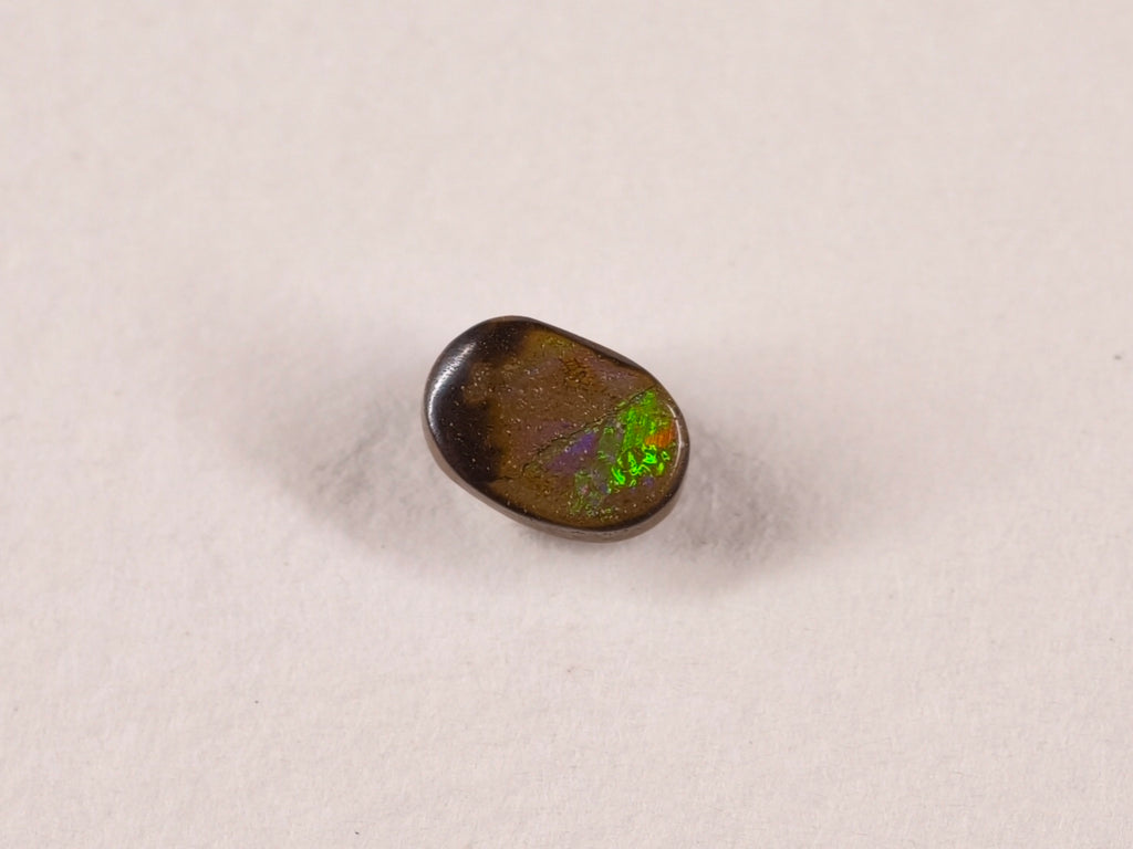 Opale boulder 0192 : petit ovale brun avec des éclats verts à une extrémité