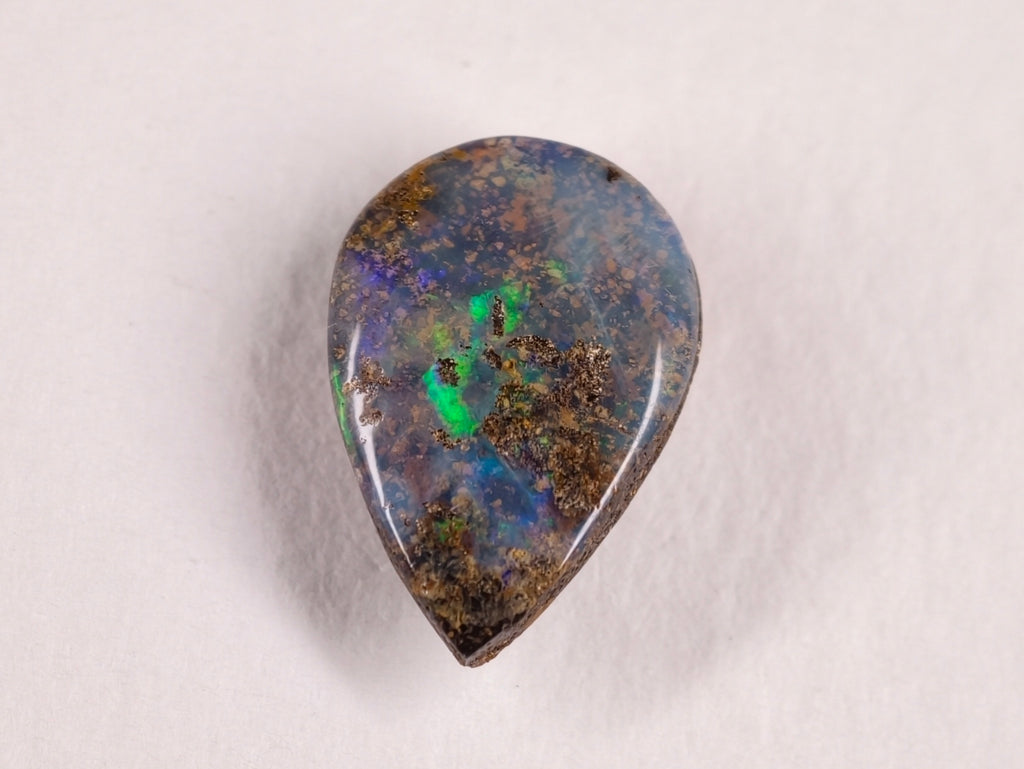 Opale boulder 0222 : face en goutte ponctuée de vert sur fond gris bleuté