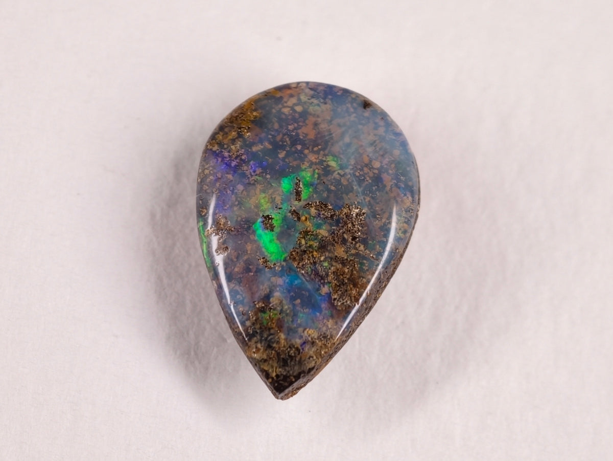 Opale boulder 0222 : face en goutte ponctuée de vert sur fond gris bleuté