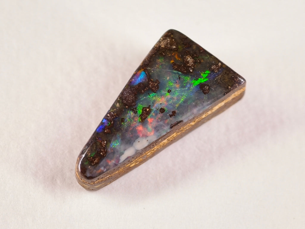 Opale boulder 0258 : forme effilée avec zone claire, îlots bruns et éclats multicolores